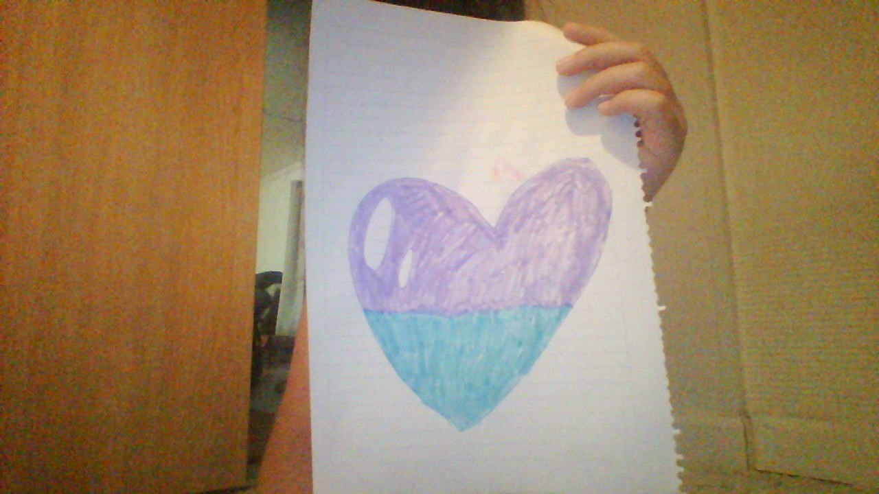 Yo mostrando un corazoncito dibujado por mí :)
